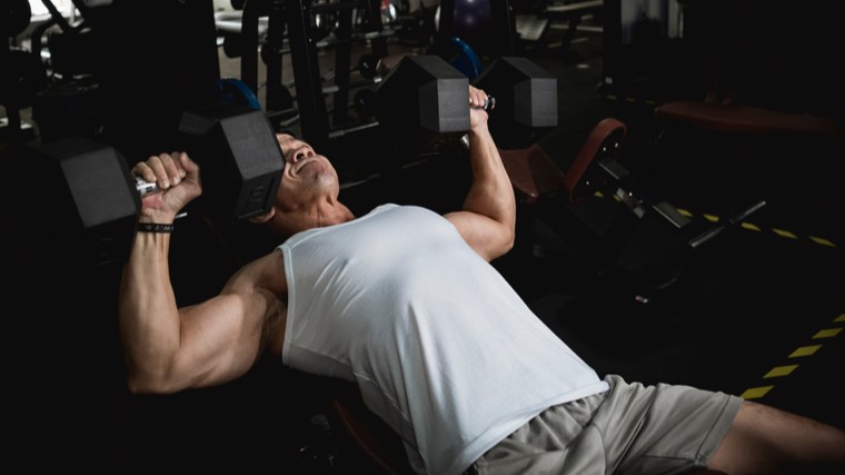 Man in gym performing incline dumbbell press
